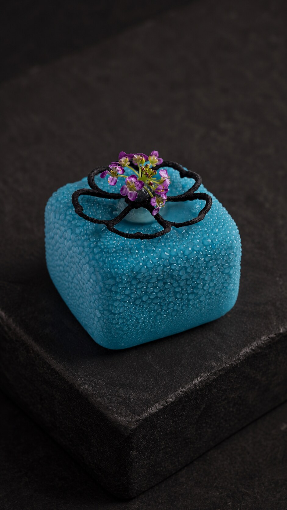 Turquoise sculptural canapé with black petals and purple flowers